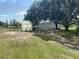 Exterior view of greenhouse, outbuilding, mature trees, and spacious backyard at 5760 Howard Creek Rd, Sarasota, FL 34241