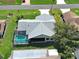 Aerial view of a house with a screened-in pool surrounded by manicured lawns and mature trees at 5832 Monroe Rd, Venice, FL 34293