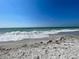 Waves gently rolling onto a sandy beach under a bright, sunny sky at 5832 Monroe Rd, Venice, FL 34293