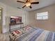 Bright bedroom featuring wood floors, stylish furniture, ceiling fan, and a cozy bed with a colorful blanket at 5832 Monroe Rd, Venice, FL 34293