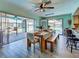Dining room with wood floors, open access to the outdoor pool area, and modern lighting at 5832 Monroe Rd, Venice, FL 34293