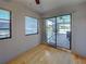 Well-lit room featuring hardwood floors, windows, and a sliding glass door at 5832 Monroe Rd, Venice, FL 34293