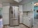 Kitchen view shows the stainless steel refrigerator and white cabinets at 5832 Monroe Rd, Venice, FL 34293