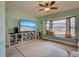 Bright living room features a large window, ceiling fan, and a TV with built in shelving at 5832 Monroe Rd, Venice, FL 34293