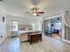 Bright primary bedroom with wood-look floors, a decorative chest, and sliding glass doors to a porch at 5832 Monroe Rd, Venice, FL 34293