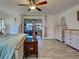 Bright primary bedroom with wood-look floors, a decorative chest, and natural light from two windows at 5832 Monroe Rd, Venice, FL 34293