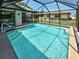 Inviting screened-in pool with pristine water, features steps for easy access, and a large deck at 5832 Monroe Rd, Venice, FL 34293