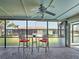 Relaxing sunroom featuring bar stools, a small table, and a ceiling fan, perfect for enjoying the outdoors at 5832 Monroe Rd, Venice, FL 34293
