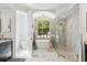 Elegant bathroom with a soaking tub, marble floors, glass shower and natural lighting from a large window at 5850 Saddle Oak Trl, Sarasota, FL 34241