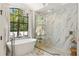 Stunning bathroom featuring a soaking tub, glass-enclosed shower, and contemporary chandelier for a spa-like experience at 5850 Saddle Oak Trl, Sarasota, FL 34241