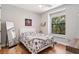 Cozy bedroom with a bright window, a bed with a patterned comforter, and wood floors at 5850 Saddle Oak Trl, Sarasota, FL 34241