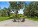 Secluded backyard fire pit with beautiful trees and comfortable outdoor seating at 5850 Saddle Oak Trl, Sarasota, FL 34241