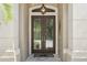 Elegant double front doors with decorative glass, flanked by stone columns, create a grand entrance to the home at 5850 Saddle Oak Trl, Sarasota, FL 34241
