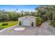 Garage with decorative compass rose and potted plants, complemented by lush tropical greenery and a circular driveway at 5850 Saddle Oak Trl, Sarasota, FL 34241