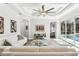 Living room with ceiling fan, view of the pool area, and modern decor at 5850 Saddle Oak Trl, Sarasota, FL 34241