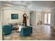 Inviting living room featuring stylish blue armchairs, neutral sofa, tiled flooring, and arched doorways at 5850 Saddle Oak Trl, Sarasota, FL 34241