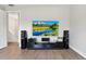Living room with hardwood floors and a large television with a scenic mountain view at 5850 Saddle Oak Trl, Sarasota, FL 34241