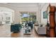 Bright living room features large windows with views of the landscaped backyard and a classic grandfather clock at 5850 Saddle Oak Trl, Sarasota, FL 34241