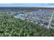 Expansive aerial view showcases a neighborhood with mature trees, a lake, and tidy residential streets at 5872 Monroe Rd, Venice, FL 34293