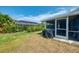 Spacious backyard featuring a screened lanai, lush landscaping, and plenty of room for outdoor activities at 5872 Monroe Rd, Venice, FL 34293