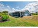 Beautiful blue house with a screened-in porch and big yard; has an immaculate lawn with mature landscaping at 5872 Monroe Rd, Venice, FL 34293