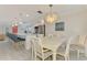 Bright dining area with an elegant chandelier, open to the modern kitchen with stainless steel appliances and island seating at 5872 Monroe Rd, Venice, FL 34293