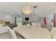 Open-concept living space with a dining area featuring a stylish chandelier, seamlessly connecting to the living room and kitchen at 5872 Monroe Rd, Venice, FL 34293