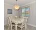 Charming dining area with seating for six, an elegant light fixture, and a view from the window at 5872 Monroe Rd, Venice, FL 34293