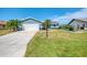 Charming single-story home with blue siding, mature landscaping, and a spacious two-car garage at 5872 Monroe Rd, Venice, FL 34293