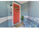 Inviting front porch with a colorful wreath, bench, and charming nautical décor at 5872 Monroe Rd, Venice, FL 34293
