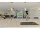 Open concept kitchen island leads to living area with comfortable seating and view to outdoor patio at 5872 Monroe Rd, Venice, FL 34293