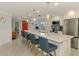 Bright kitchen boasts an eat-in island with seating, pendant lighting, white cabinets, and stainless steel appliances at 5872 Monroe Rd, Venice, FL 34293