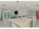 Open concept kitchen features an island with seating and sink, leading to a living room and screened-in porch at 5872 Monroe Rd, Venice, FL 34293
