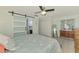 Comfortable main bedroom, featuring barn door to bathroom, complemented by a dresser, closet, and ceiling fan at 5872 Monroe Rd, Venice, FL 34293