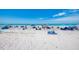 A sunny, sandy beach full of people, umbrellas, and chairs enjoying a day by the ocean at 5872 Monroe Rd, Venice, FL 34293