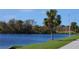 Picturesque waterfront view featuring lush greenery and a serene blue lake on a clear sunny day at 5872 Monroe Rd, Venice, FL 34293
