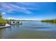 Scenic waterfront view with a small boat near a wooden dock, and lush trees in the background at 5872 Monroe Rd, Venice, FL 34293