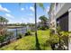 Landscaped backyard with a pond, fountain, and a black metal fence under a bright blue sky at 600 Gardens Edge Dr # 613, Venice, FL 34285
