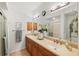 Well-lit bathroom with a double sink vanity, large mirrors, and a walk-in shower at 600 Gardens Edge Dr # 613, Venice, FL 34285