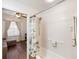Tiled tub/shower combination with hand-held sprayer, next to adjacent room with hardwood floors at 600 Gardens Edge Dr # 613, Venice, FL 34285
