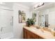 Neutral bathroom with a wide mirror over vanity with oak cabinets and a shower-tub combination at 600 Gardens Edge Dr # 613, Venice, FL 34285