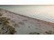 Scenic aerial shot of a beach, showcasing the expansive shoreline with crowds and a lifeguard tower at 600 Gardens Edge Dr # 613, Venice, FL 34285