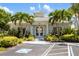 Community clubhouse with lush landscaping and prominent accessibility parking in front at 600 Gardens Edge Dr # 613, Venice, FL 34285