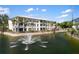 Exterior of the condo community buildings with a water feature and lush landscaping at 600 Gardens Edge Dr # 613, Venice, FL 34285