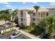 Beautiful condo building with lush tropical landscaping, a parking lot, and private balconies in a sunny, inviting setting at 600 Gardens Edge Dr # 613, Venice, FL 34285