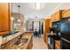 Well-appointed kitchen with granite counters, breakfast bar, wooden cabinets, and modern black appliances at 600 Gardens Edge Dr # 613, Venice, FL 34285