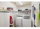 Well-lit laundry room with white appliances, wire shelving, and a water heater at 600 Gardens Edge Dr # 613, Venice, FL 34285