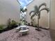 This outdoor patio features brick pavers, tropical landscaping, and a unique stone table at 612 Bird Bay S Dr # 308, Venice, FL 34285