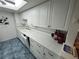 Bright kitchen featuring modern white cabinets and updated countertop with a dishwasher at 612 Bird Bay S Dr # 308, Venice, FL 34285