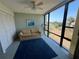 This sun room features a pull-out sofa, a lamp, and a beautiful view from the large windows at 612 Bird Bay S Dr # 308, Venice, FL 34285